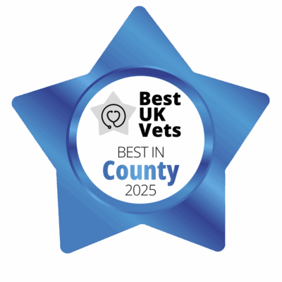 A blue, star-shaped badge with the words Best UK Vets, Best in County 2025 in the middle.