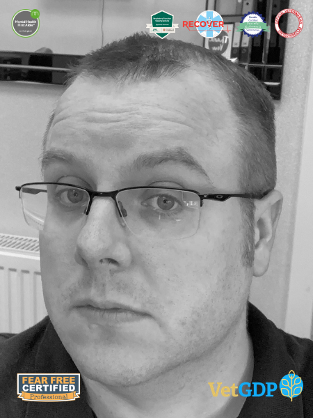 A man with glasses looks at the camera. There are a few certification badges on the image, such as Fear Free Certified Professional and VetGDP.