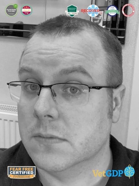 A person with short hair and glasses is looking at the camera. There are several certificate badges shown at the top, and Fear Free Certified and VetGDP logos appear at the bottom.
