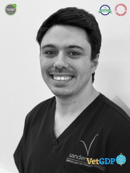 A man wearing dark medical scrubs smiles at the camera in a black and white photo. Veterinary and certificate logos can be seen in the corners of the picture.