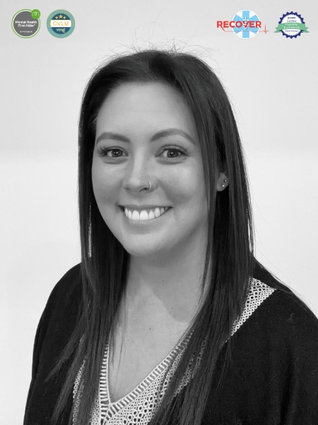 Black and white photo of a happy woman with straight hair and a nose ring, in front of a plain white background. Four certification logos are shown above her.