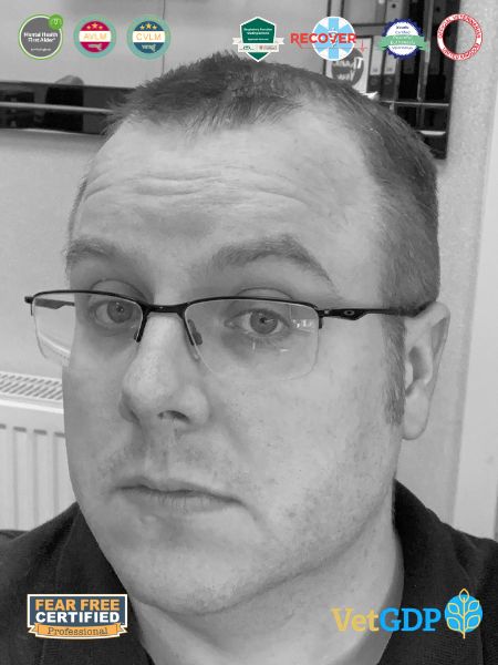 A man with short hair and glasses looks at the camera. Different badges for certificates are shown at the top. The Fear Free Certified and VetGDP logos appear at the bottom.