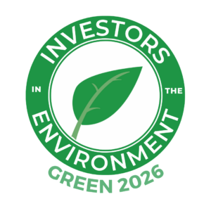 A round green logo with a leaf in the middle. The words say Investors in the Environment Green 2026.